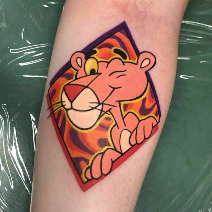Cartoon tattoo featuring a winking pink panther with vibrant colors on forearm.
