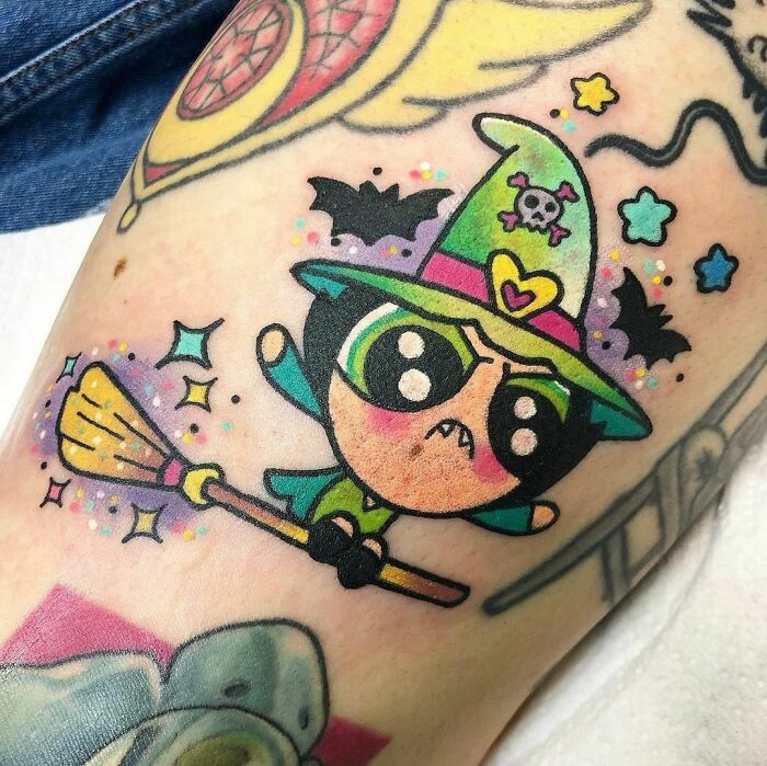 Colorful cartoon tattoo of a witch on a broom, reminiscent of childhood favorites.