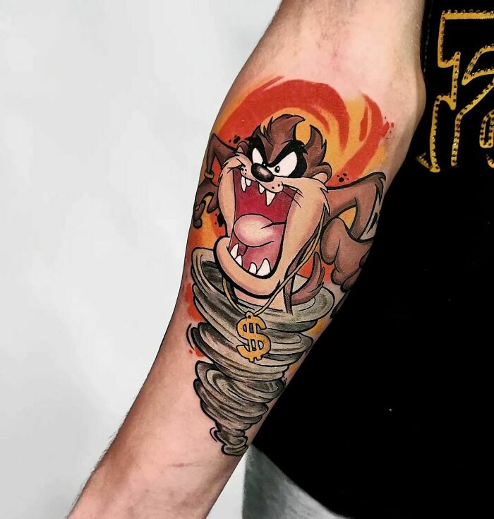 Tattoo of a cartoon character in a whirlwind on an arm, evoking childhood favorites.