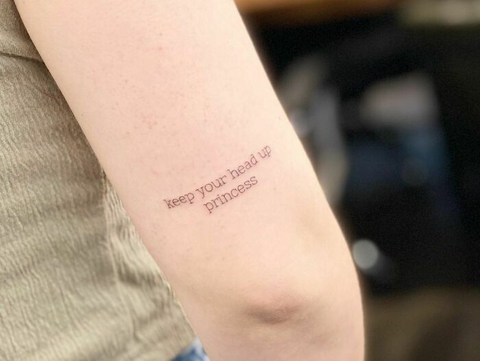 Minimalist arm tattoo saying "keep your head up princess," showcasing creative word tattoos.