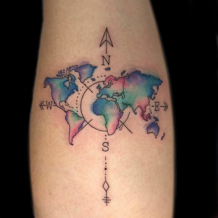 Watercolor tattoo of a world map with compass design, featuring soft pastel colors for inkspiration.