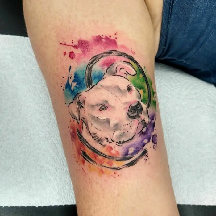 Watercolor tattoo of a dog's portrait in vibrant colors, blending art with inkspiration.