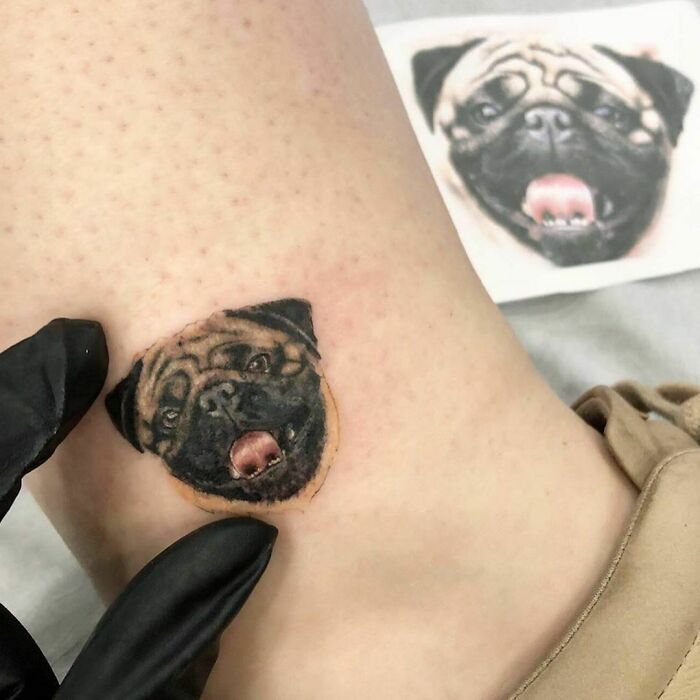 Tattoo of a pug's face on a person's skin, celebrating furry friends.