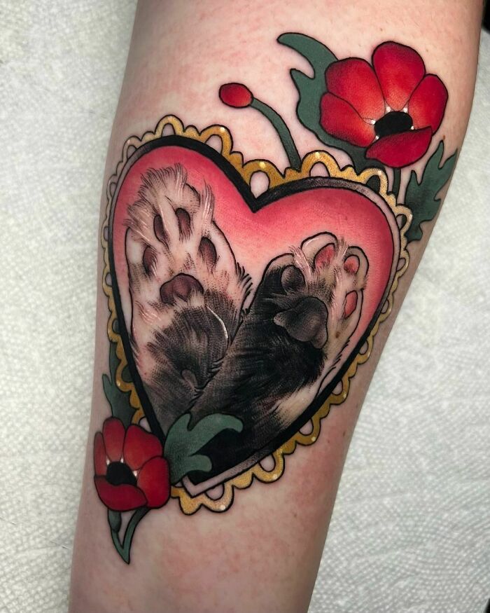 Heart-shaped pet tattoo featuring paw prints and vibrant red flowers.