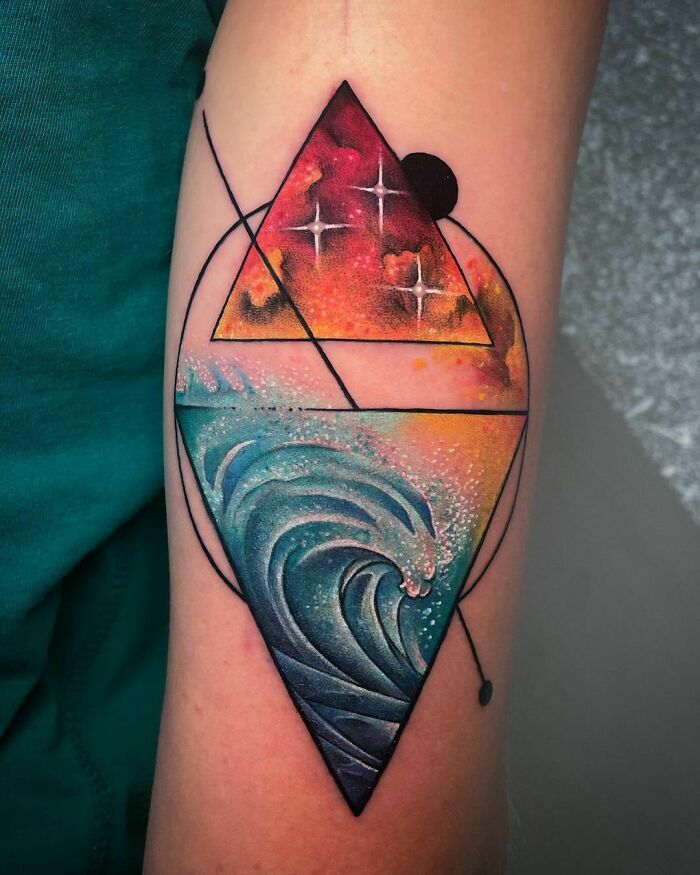 Watercolor tattoo of abstract geometric shapes on arm, featuring vibrant ocean waves and cosmic colors.