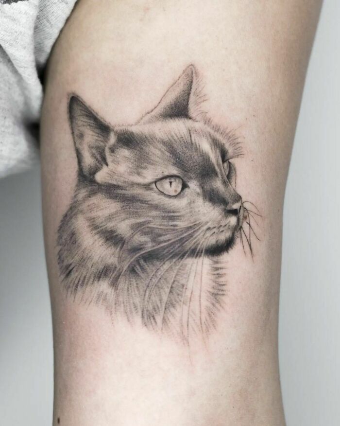 Detailed pet tattoo of a cat's face, capturing lifelike features to immortalize companionship.