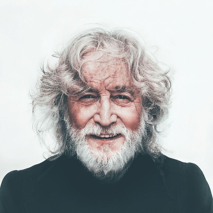 AI-generated image of an elderly man with white hair and beard, smiling broadly against a plain background.