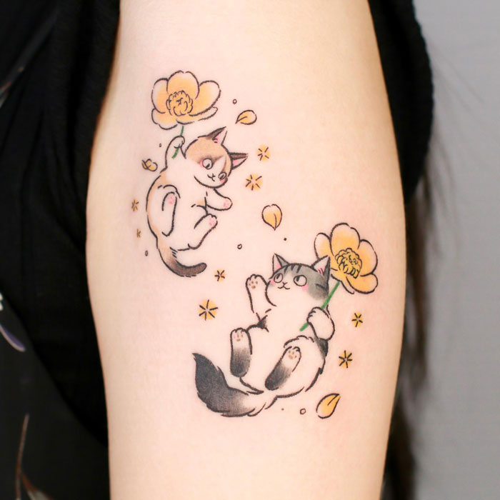 Playful cat tattoos with flowers celebrating the animal kingdom on skin.