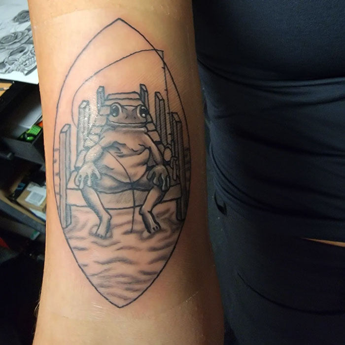 Frog tattoo on arm featuring detailed line art of a frog on a chair, showcasing unique animal tattoo design.