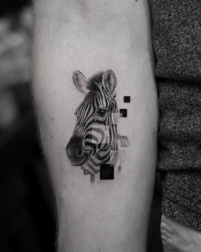Stylized zebra animal tattoo with geometric design on a person's arm.