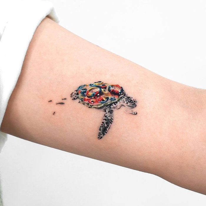 Colorful sea turtle tattoo on arm celebrating the animal kingdom.
