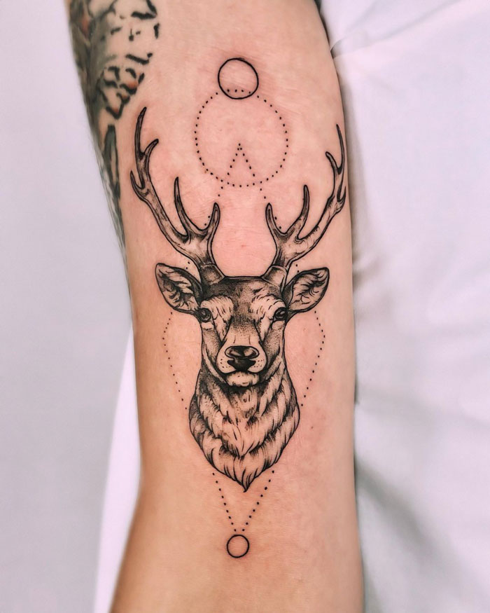 Deer tattoo on forearm with geometric design, showcasing creative animal tattoo ideas.
