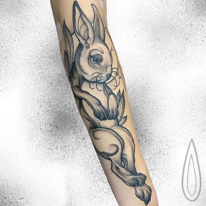 Tattoo of a rabbit on an arm, showcasing detailed animal art design.