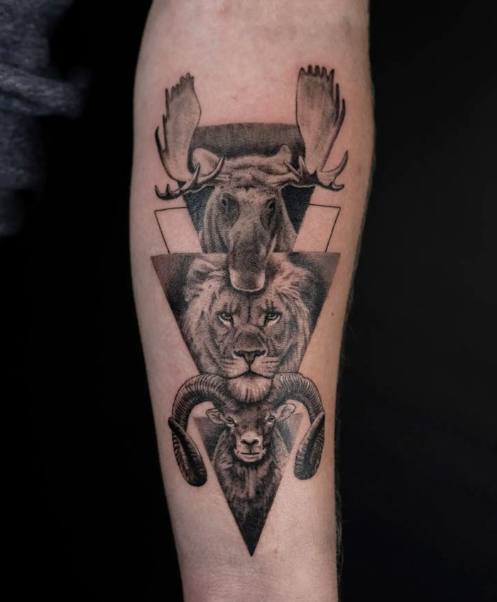 Animal tattoo showcasing moose, lion, and ram in geometric design on forearm.
