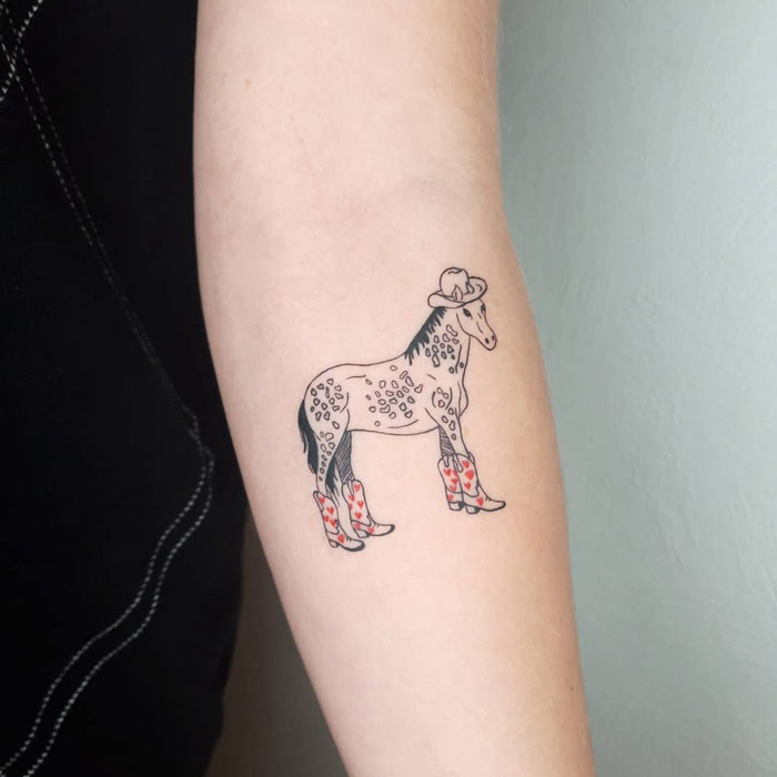 Tattoo of a horse wearing a cowboy hat and boots, celebrating the animal kingdom.