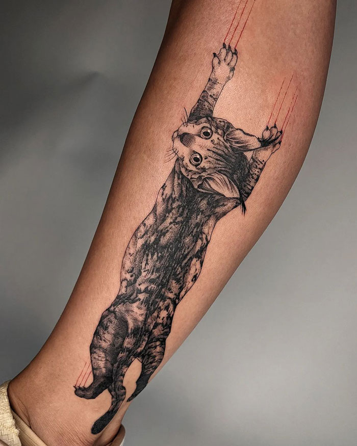 Animal tattoo of a realistic cat scratching on a person's arm, showcasing detailed fur and dynamic action lines.
