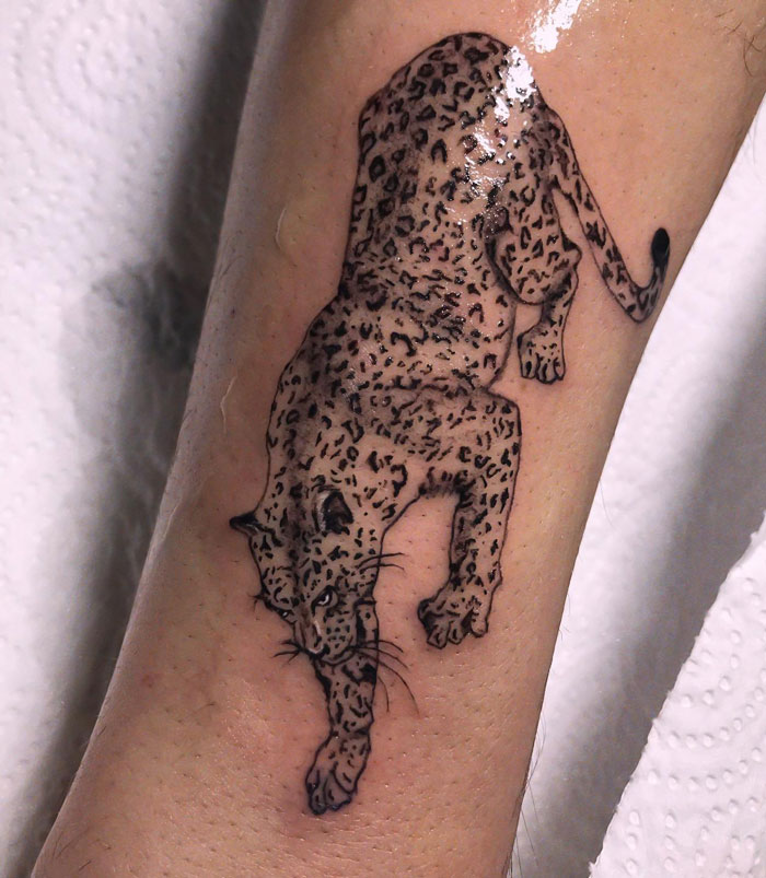 Leopard tattoo design on forearm, showcasing intricate animal art details.