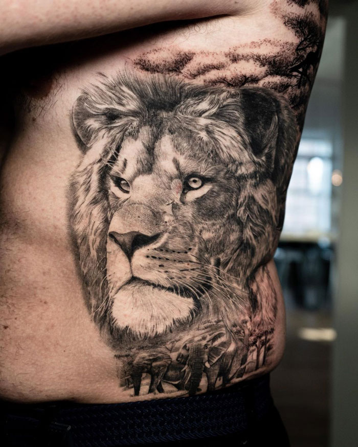 Detailed lion tattoo on a person's side, showcasing intricate shading and artistic animal design.
