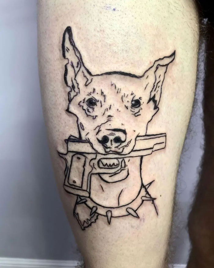 Line art dog tattoo on thigh, celebrating animal tattoos with a gun in its mouth and spiked collar.