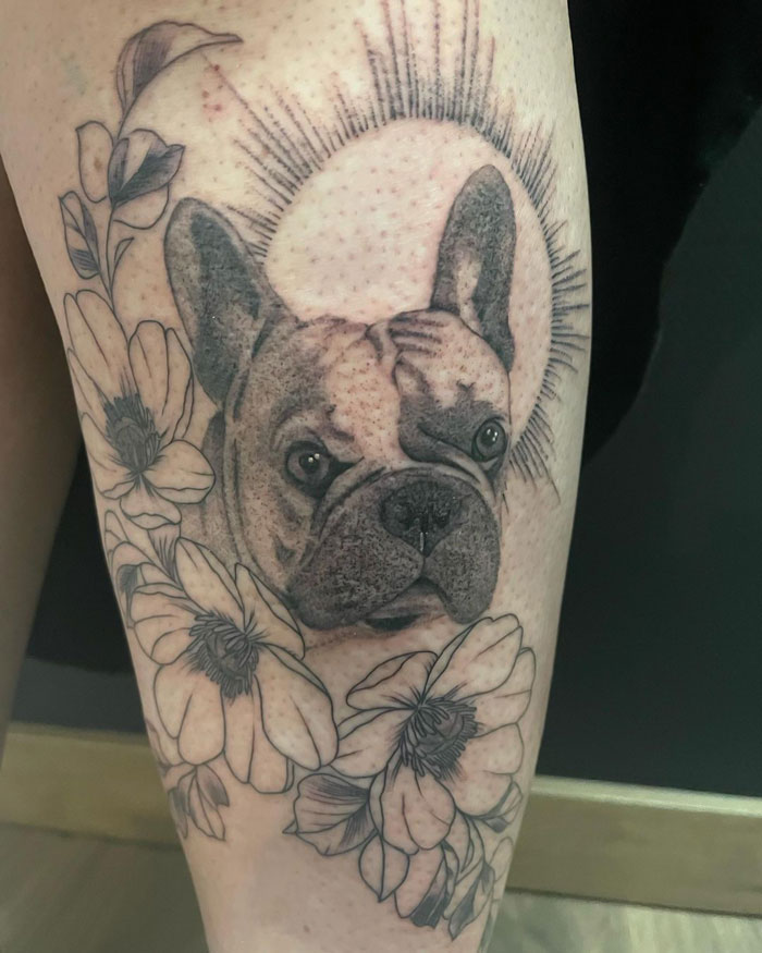 Tattoo of a dog surrounded by flowers, celebrating the animal kingdom.