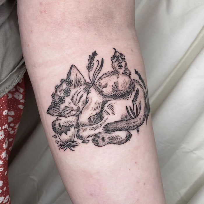 Tattoo of a sleeping fox surrounded by flowers, showcasing simplicity and realism in animal art.