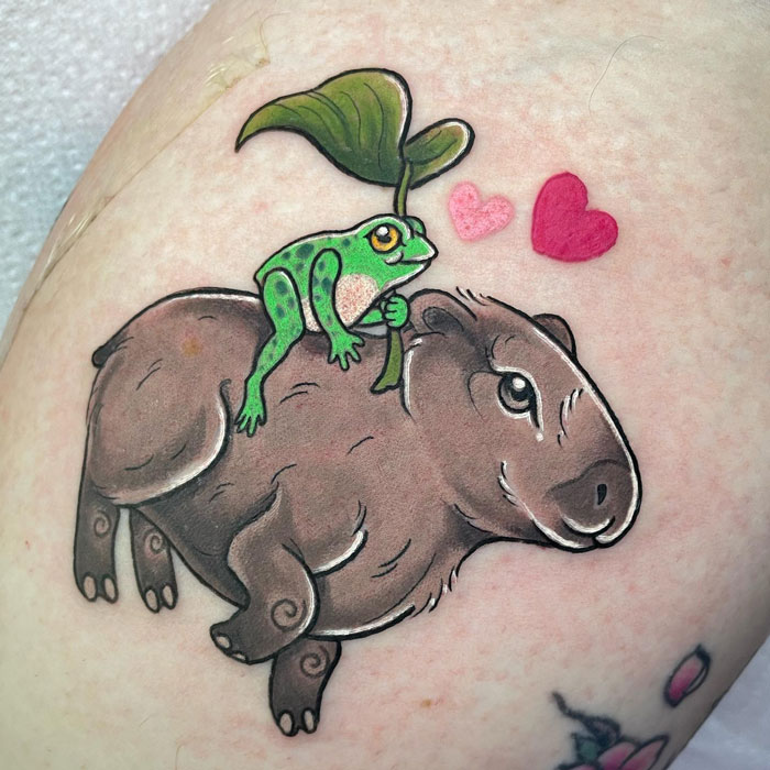 Colorful animal tattoo of a frog on a capybara with hearts, showcasing creative tattoo ideas.