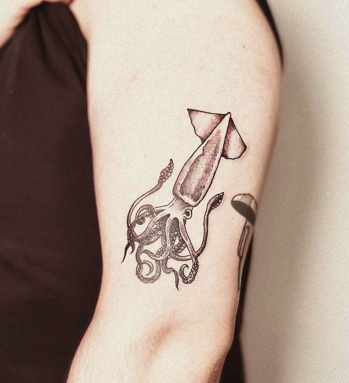 Squid tattoo design on arm, showcasing unique animal art for creative inspiration.