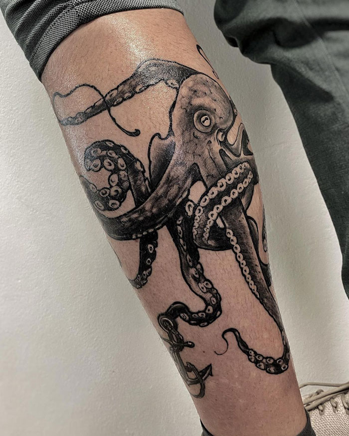Octopus tattoo on leg, detailed black ink design showcasing the animal kingdom.