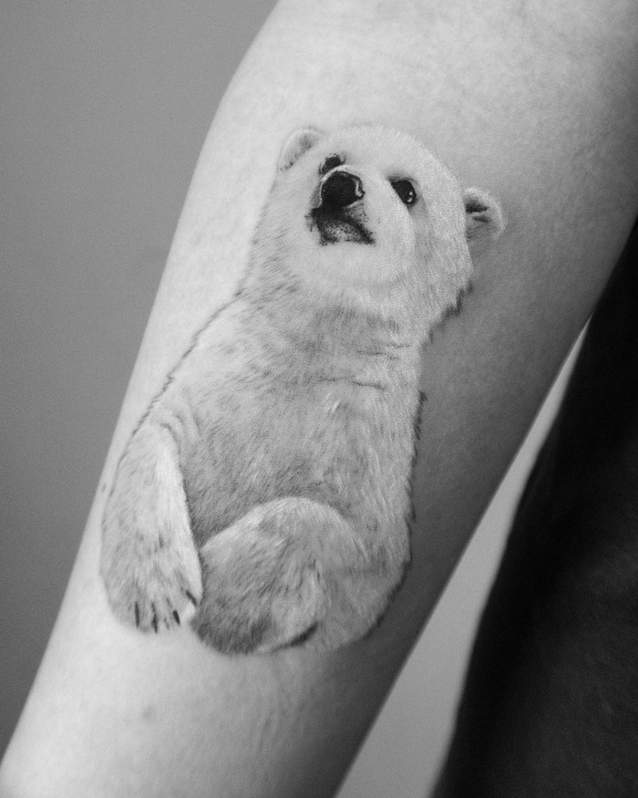 Polar bear animal tattoo on forearm, showcasing intricate details and realism.