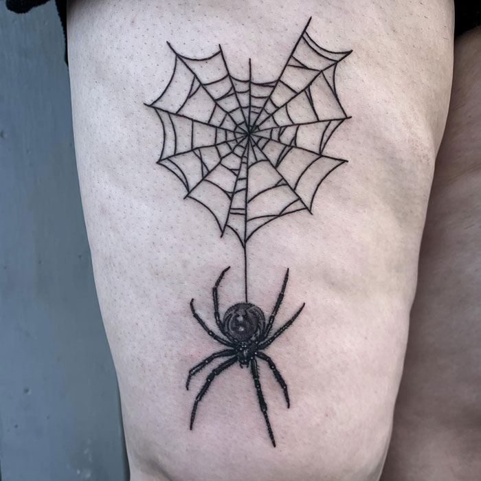 Spider tattoo with a web, showcasing intricate animal tattoo design.