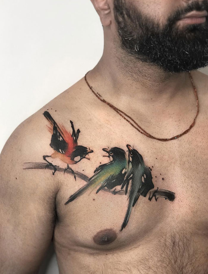 Colorful bird tattoo design on a man's chest, showcasing creative animal tattoo ideas.