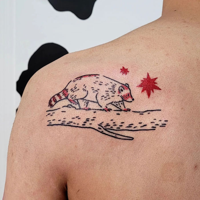 Minimalist raccoon tattoo on the shoulder, showcasing simplicity and realism in animal design.