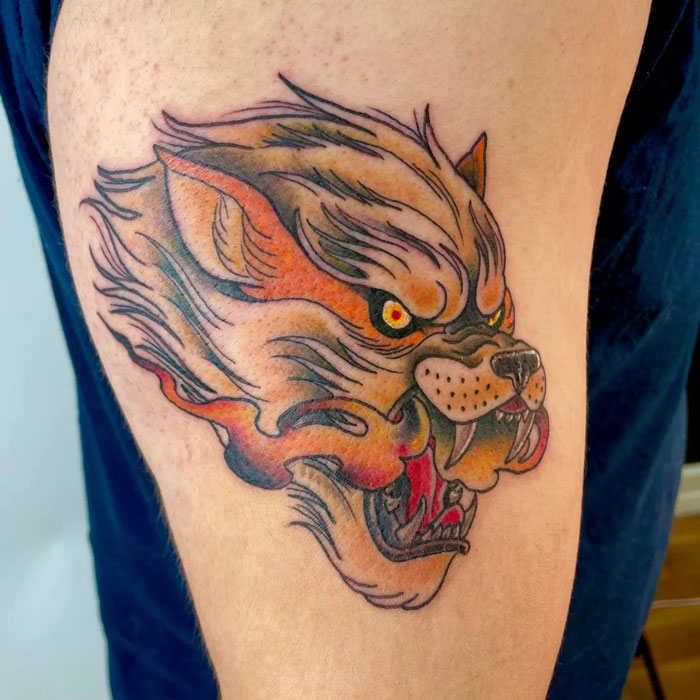 Realistic wolf tattoo design on upper arm showcasing animal tattoo simplicity.
