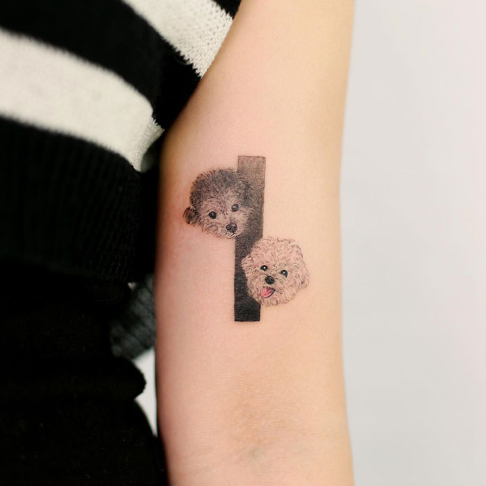 Animal tattoos of two small dogs on an arm, showcasing creative and playful design.