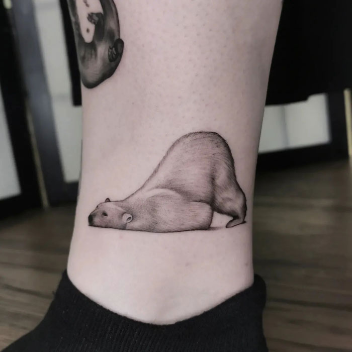 Minimalist realistic polar bear tattoo on leg.