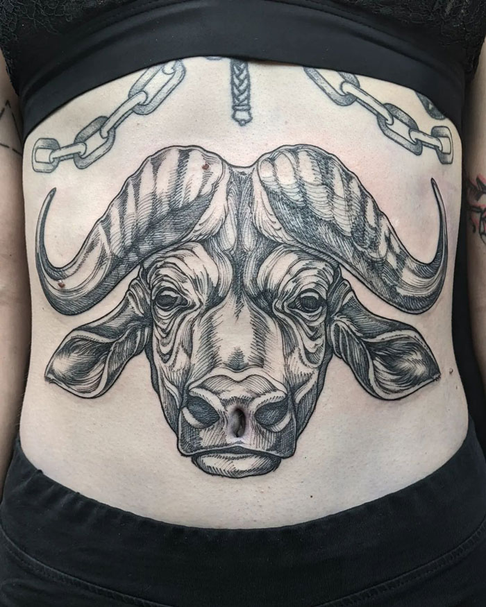 Buffalo head tattoo on a person's torso, showcasing detailed artistry celebrating the animal kingdom.