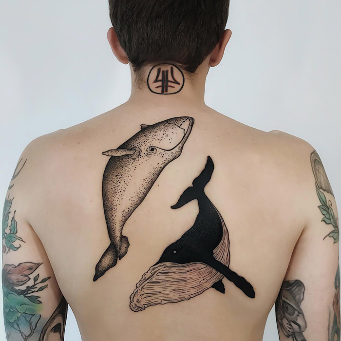 Back tattoo featuring artistic whale designs, showcasing unique animal tattoo ideas.