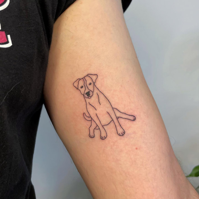 Simple realistic animal tattoo of a dog on an arm.