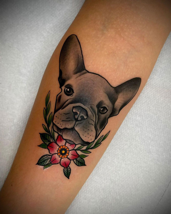 Tattoo of a French bulldog with a floral design on an arm, showcasing animal tattoo inspiration.