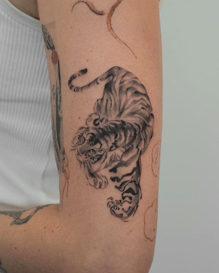 Realistic tiger tattoo on arm, showcasing animal tattoo ideas that emphasize simplicity.