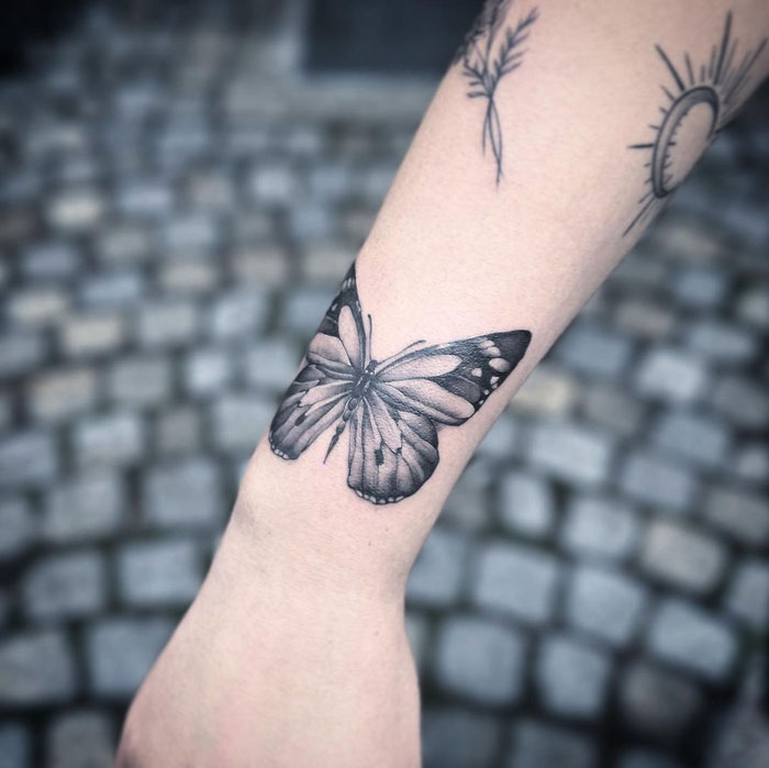 Butterfly tattoo design on forearm with delicate shading, perfect for animal tattoo enthusiasts.