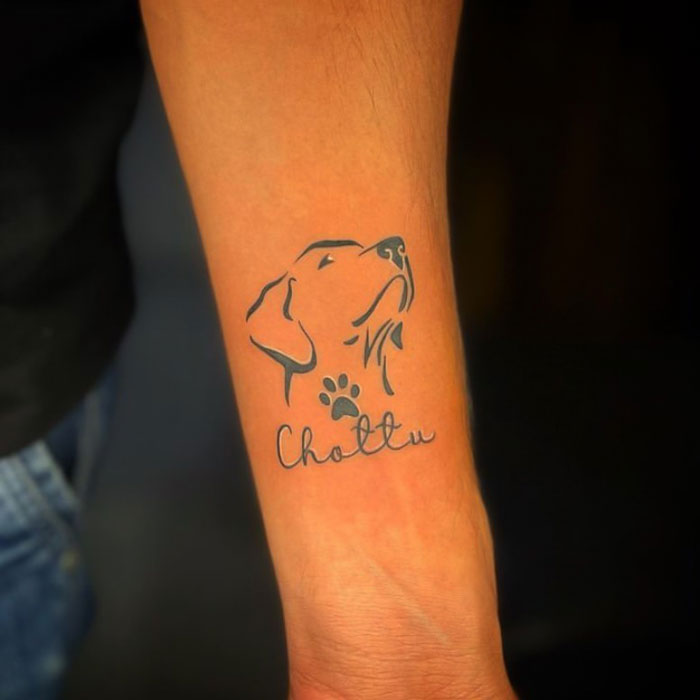 Dog tattoo with paw print and "Chottu" text on arm, showcasing an elegant animal tattoo design.