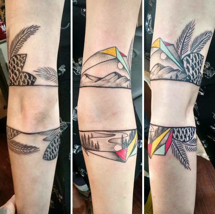 Armband tattoo featuring geometric and nature elements with feathers and mountains.