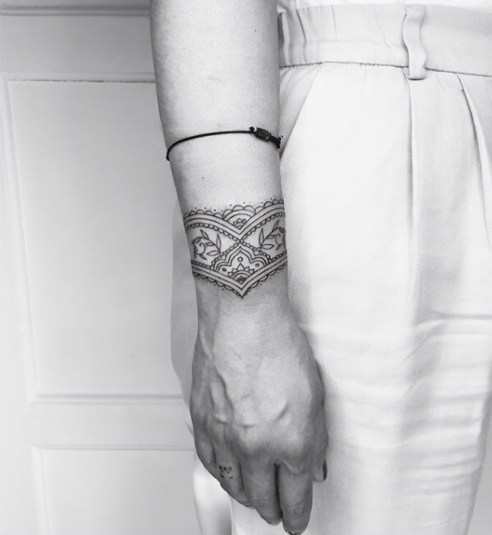 Intricate armband tattoo design on a person's arm, showcasing detailed patterns and symbols.