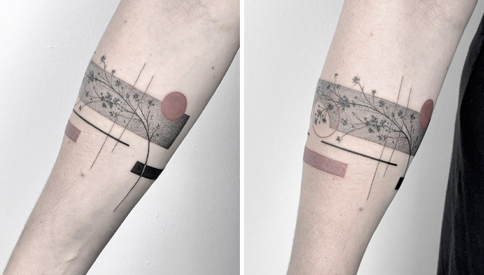 Minimalistic geometric armband tattoo design with floral elements on forearm.
