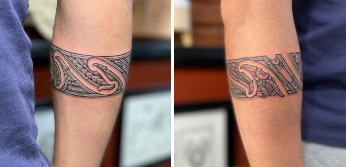 Ornate armband tattoo design featuring intricate geometric patterns on a person's lower arm.