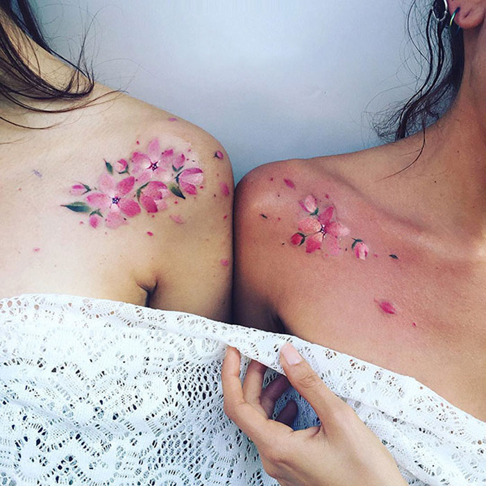 Floral BFF tattoos on shoulders, showcasing matching friendship ink designs.