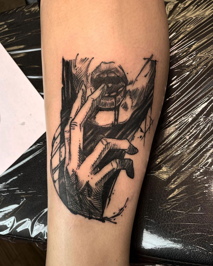 Lower leg tattoo of a hand holding a mouth, showcasing intricate linework and shading.