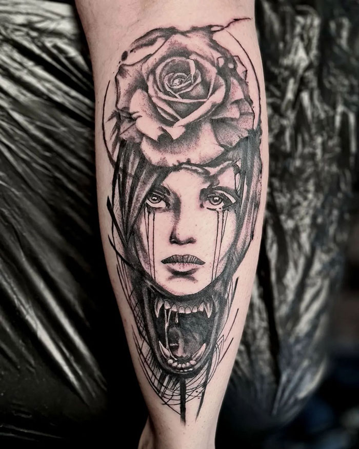 Calf tattoo featuring a surreal design with a rose and dramatic face illustration.