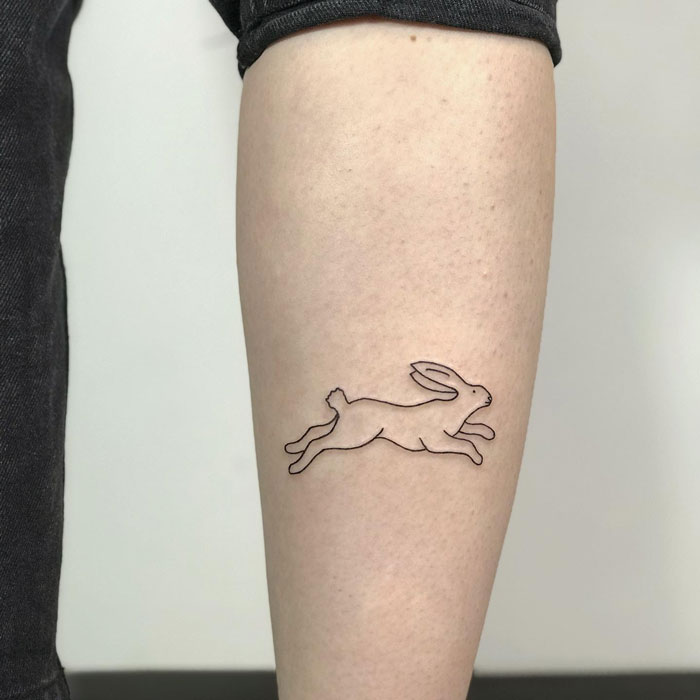 Minimalistic rabbit calf tattoo showcasing coolness.